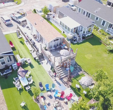 Aerial view of a modular home park featuring houses with wooden decks and landscaped yards.