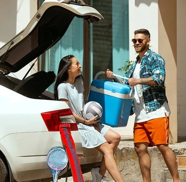 Un hombre y una mujer de pie junto a un automovil.