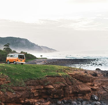 Sunrise over a campervan parked on a scenic cliffside, ready for a day of exploration.