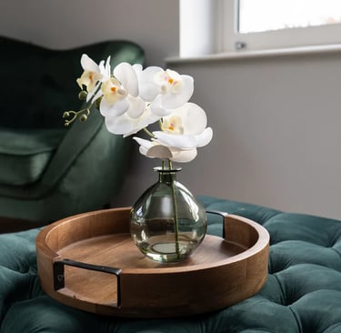 a vase with flowers in a vase on a tray orchid