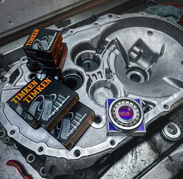 Timken and NSK tapered roller bearings sitting on a clean aluminium transmission housing.