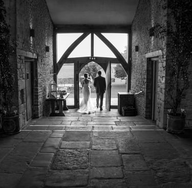 black and white image of newly weds in arch way 