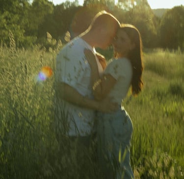 a man and woman kissing in a field