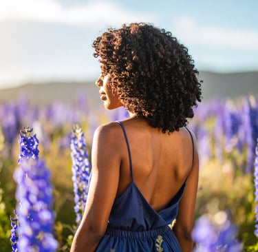 black woman in a field full of larkspur
