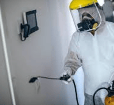 Man in hazmat suit disinfecting room
