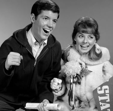 a young man and woman wearing a homecoming mum while cheering and showing their school spirit