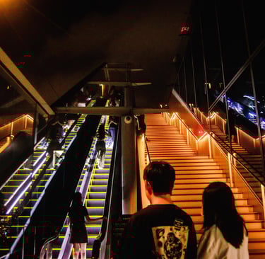 Shibuya Sky: a couple of people walking up stairs in a building