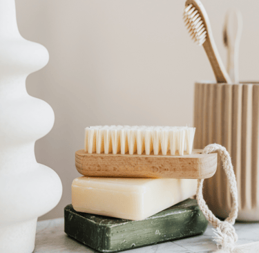 2 bars of soap stacked on top of each other & a nail brush on top of them