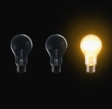a group of three light bulbs with a glowing yellow light bulb