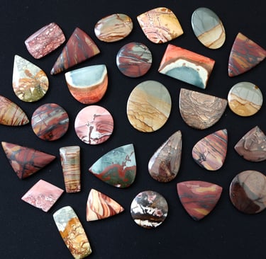 a large selection of hand cut scenic jasper cabochons in a variety of shapes