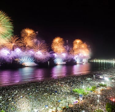 fireworks in the sky over a beach with people watching fireworks