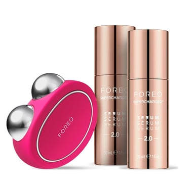 FOREO BEAR microcurrent facial toning device in fuchsia pink with two rose gold bottles of FOREO Sup