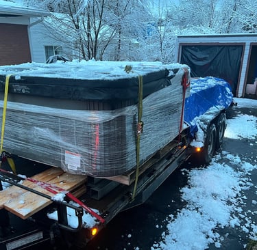 A hot tub and lumber loaded on a large trailer for delivery