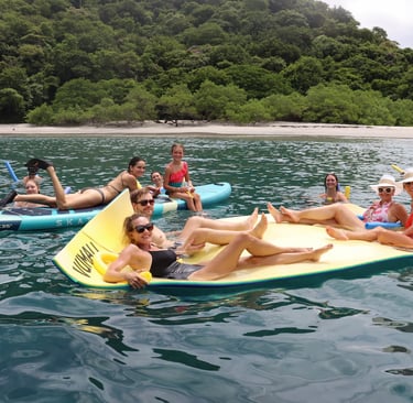 Guests enjoying floating mats and water activities during luxury catamaran experience in Papagayo