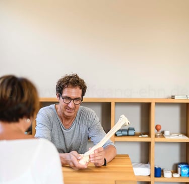 a man and woman sitting at a table with a book
