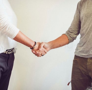 two men shaking hands with a woman in a white shirt