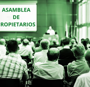 Asamblea de propietarios en edificio multifamiliar debatiendo Presupuesto Anual y cuotas comunes
