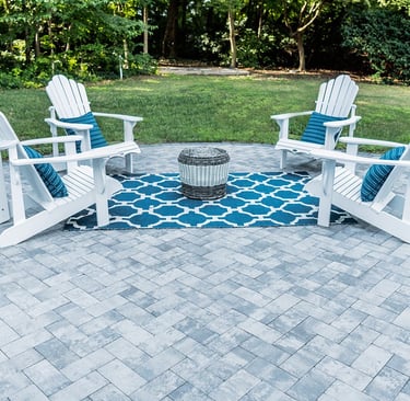 a patio with white chairs 