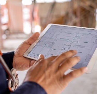 home builder looking at blueprint on tablet