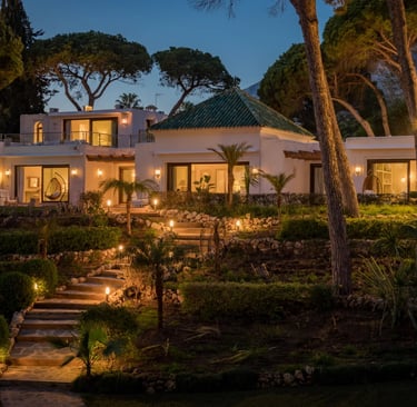 Evening exterior view with landscaped gardens and illuminated façade