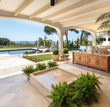 Covered terrace with fountain, pool and sea views