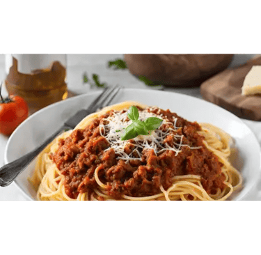 Μακαρονάδα με κιμά και βασιλικό σε λευκό πιάτο