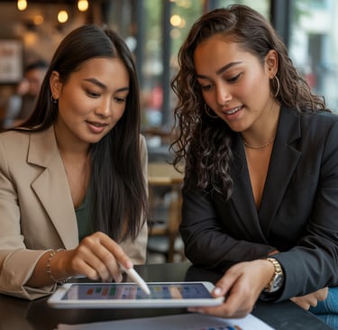 two women sitting at a table with papers and papers