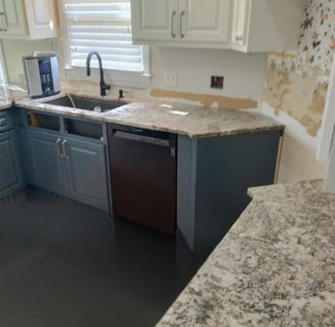 Modern kitchen with blue cabinets and multicolor granite countertops
