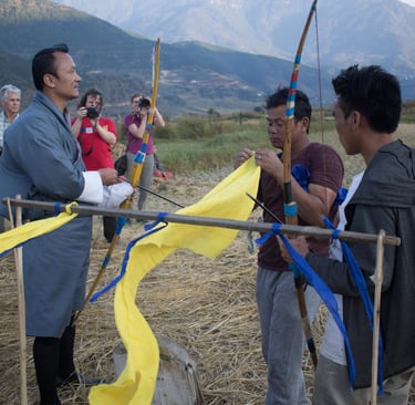drukyul-delights-ceo-putting-demo-on-traditional-archery-to-his-group-getting-photographs