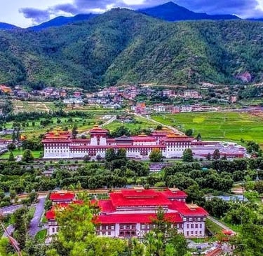 Trashichho-Dzong-Fortress-With-The-Backdrop-View-of-Green-Pristine-Mountain