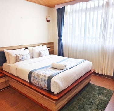 A scenic view a luxury hotel in Darjeeling, showcasing its traditional architecture in the hills