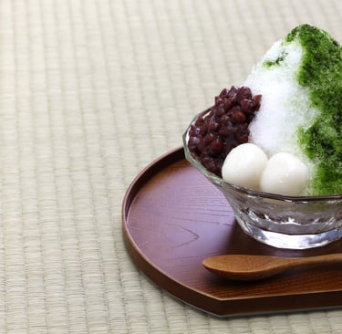 a bowl of shaved ice with matcha and red beans