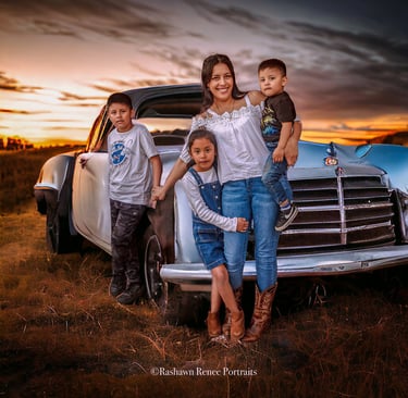 a family posing for a photo in front of a old vintage car