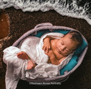 a baby boy is sleeping in a basket with his head on a blanket at thte beach