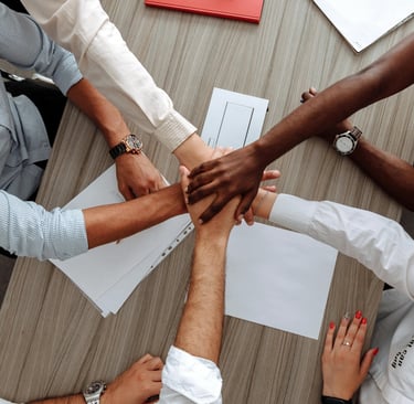 5 people putting their hand up on each other