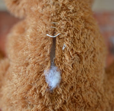 Gros plan sur une peluche abîmée avec rembourrage visible