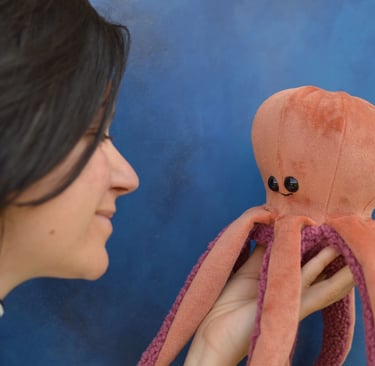 Créatrice tenant une peluche pieuvre artisanale saumon