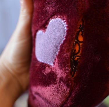 Détail de la poche sous le cœur d’une peluche amour cousu artisanale