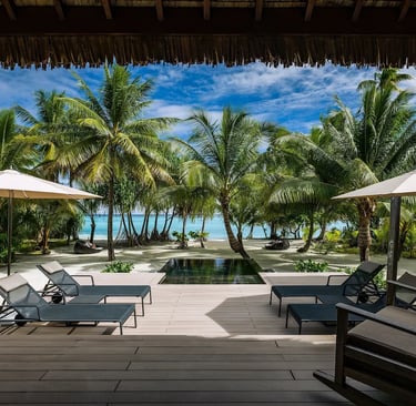 he Brando:  A serene private villa emerges amidst swaying palm trees on a pristine, white-sand beach