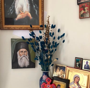 Coin prière de la maison de Berdiaev avec icônes orthodoxes, portrait de saint et vase de fleurs.