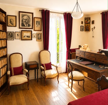 Bureau en bois de Nicolas Berdiaev à Clamart avec portraits au mur, fauteuils et bibliothèque.