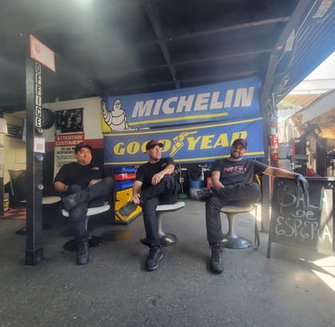 Fast Tire Shop mechanics team taking a break at the East Los Angeles workshop under a Michelin and G