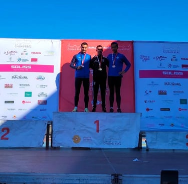 three men standing on a stage with medals