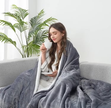 girl drinking tea in gray electric throw