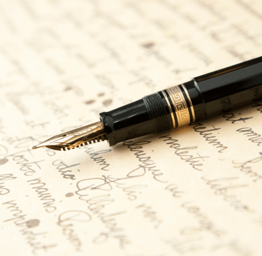 Uma caneta tinteiro sobre uma folha manuscrita