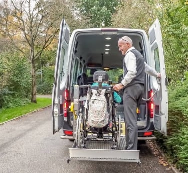 a man in a wheelchair lifter with a bicycle