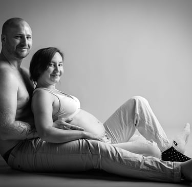 Portrait d'un couple assis au sol avec femme enceinte