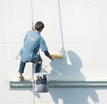 a man is painting a wall with a paint roller