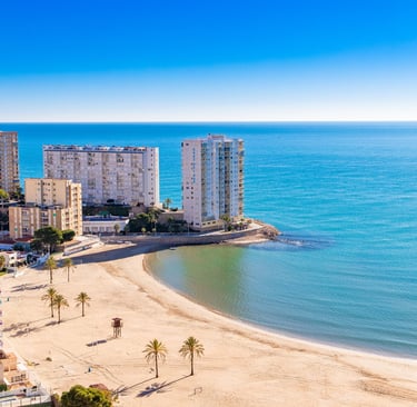 a beach with a view of a beach and a city Cullera