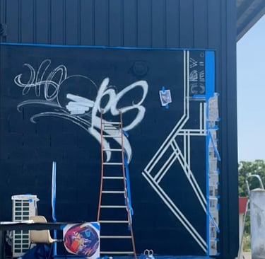 un mur noir avec le début d'un graffiti blanc